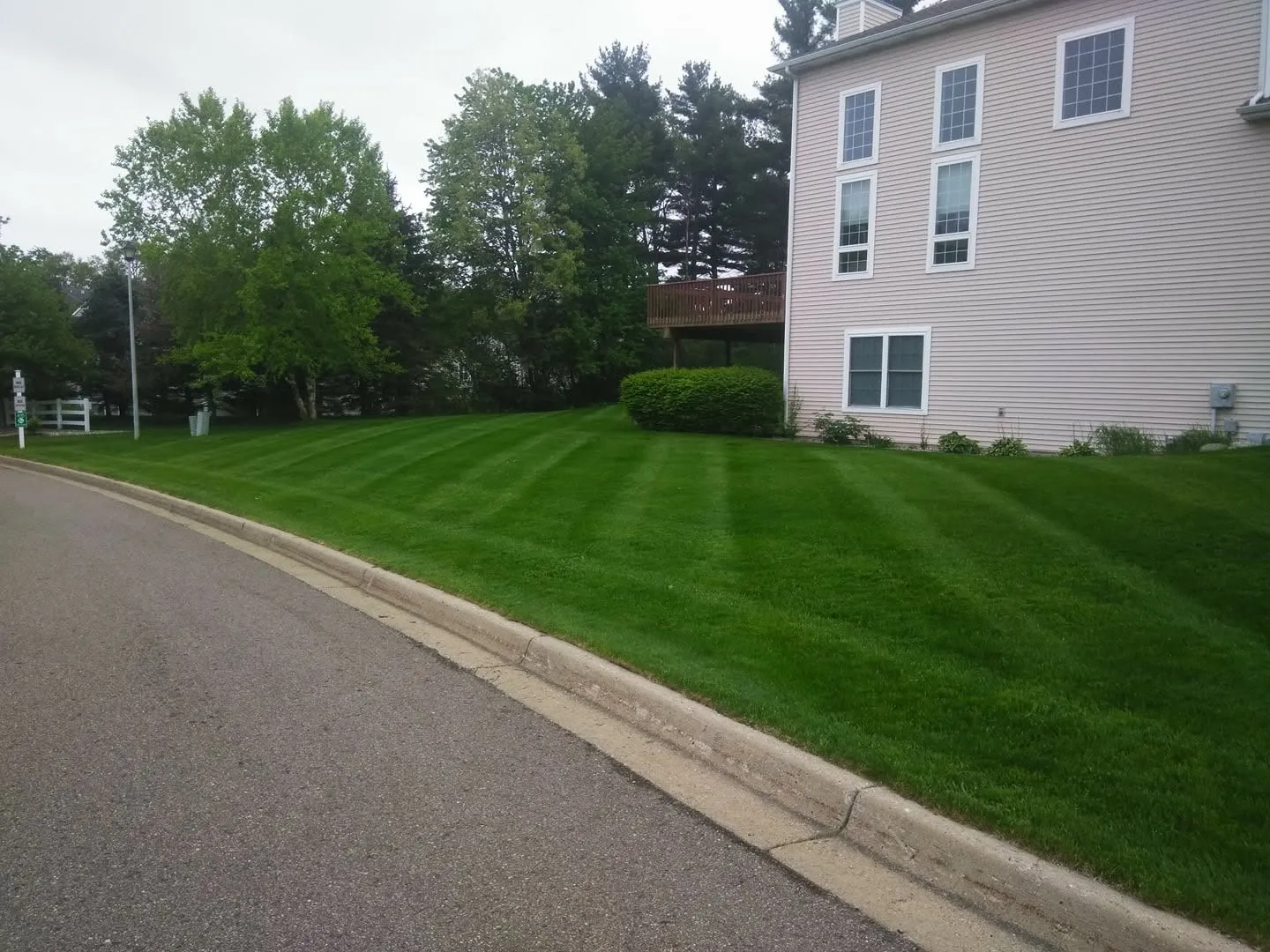 Freshly mowed front lawn with straight light and dark stripes in front of a ranch home in Kalamazoo